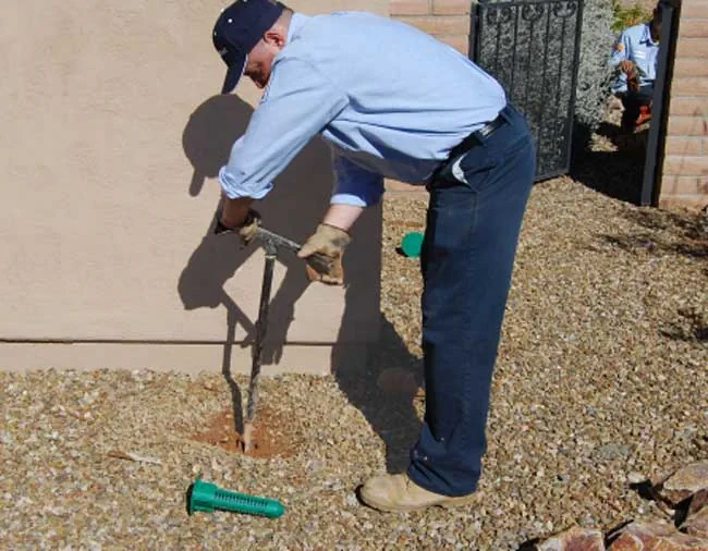 Essential Pest technician installing Sentricon Termiticide